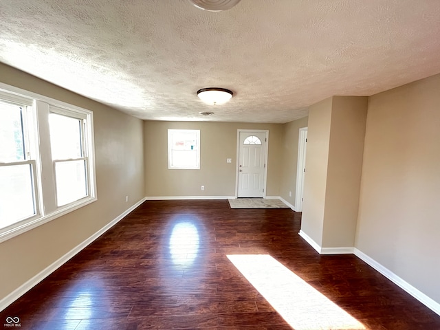 spare room featuring dark hardwood / wood-style floors and a textured ceiling