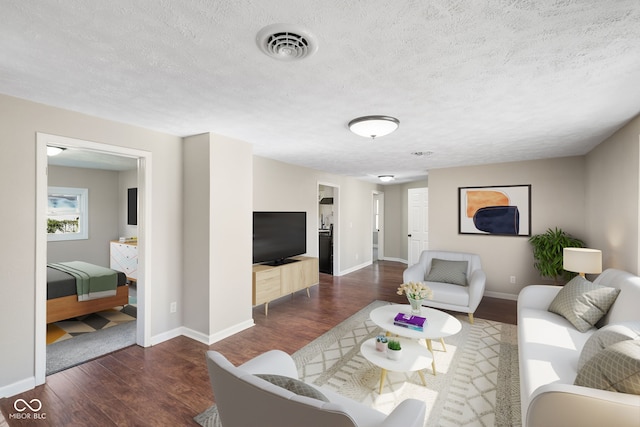 living room with dark hardwood / wood-style flooring and a textured ceiling