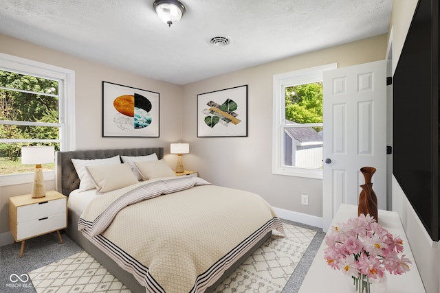 bedroom with multiple windows and a textured ceiling