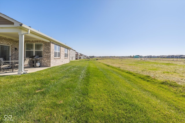 view of yard featuring a rural view and a patio area