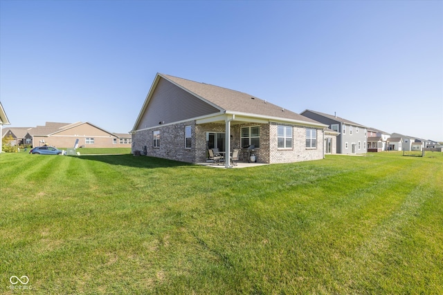 back of property featuring a lawn and a patio