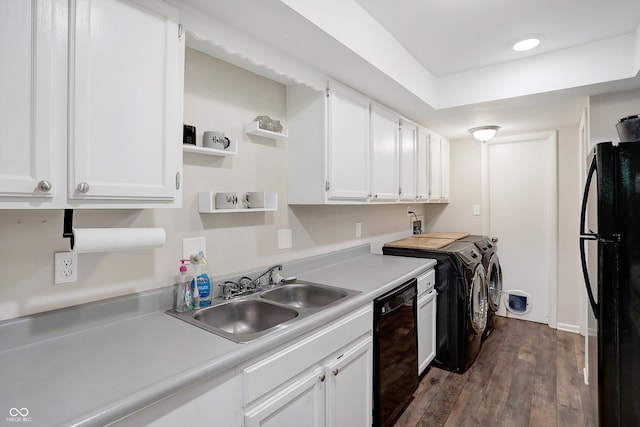 kitchen with white cabinets, sink, black appliances, dark hardwood / wood-style floors, and separate washer and dryer