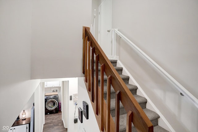 stairway featuring hardwood / wood-style flooring and washer / dryer