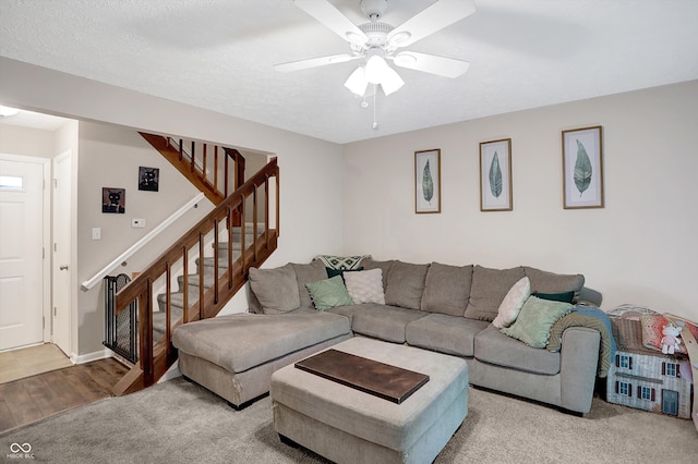 living room featuring ceiling fan, wood-type flooring, and a textured ceiling