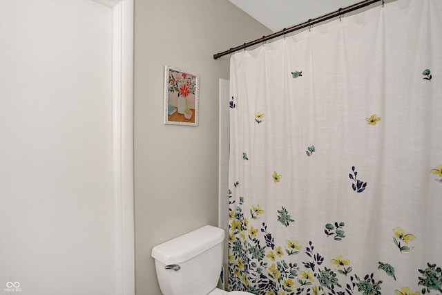 bathroom featuring a shower with curtain and toilet