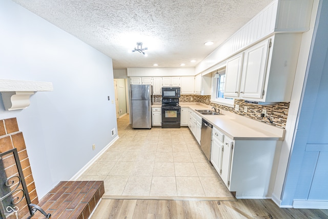 kitchen featuring tasteful backsplash, light hardwood / wood-style flooring, sink, black appliances, and white cabinetry