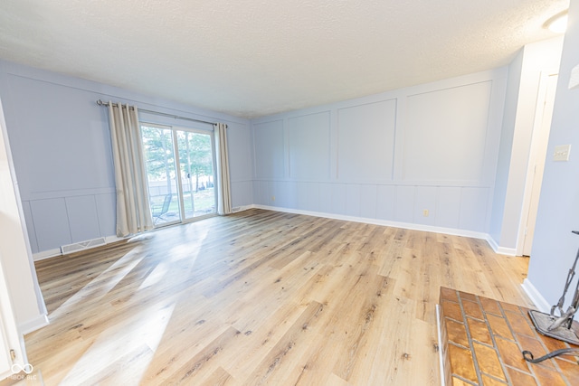 empty room featuring a textured ceiling and light wood-type flooring