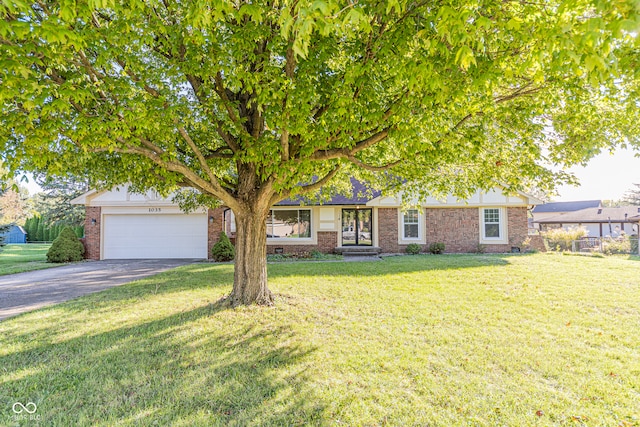 view of property hidden behind natural elements with a garage and a front yard