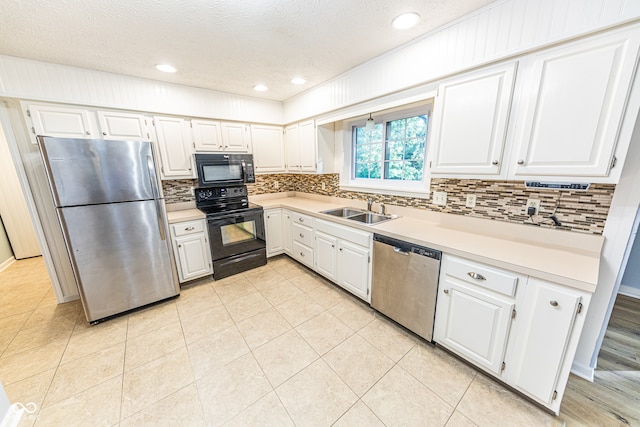 kitchen featuring black appliances, tasteful backsplash, sink, white cabinetry, and a textured ceiling