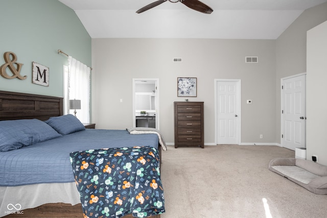 bedroom with lofted ceiling, light colored carpet, ensuite bathroom, and ceiling fan