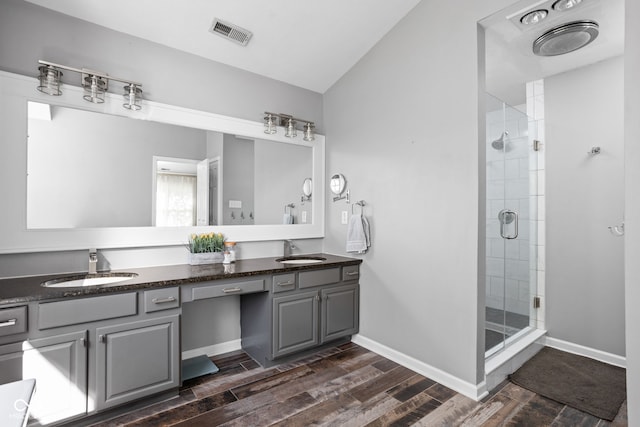 bathroom with lofted ceiling, an enclosed shower, hardwood / wood-style flooring, and vanity