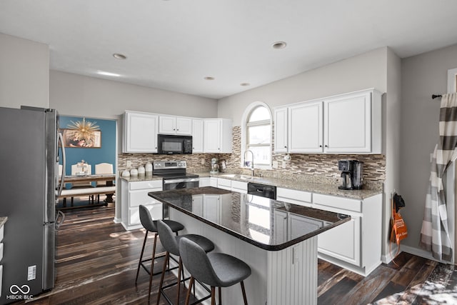 kitchen featuring white cabinets, sink, black appliances, dark hardwood / wood-style floors, and a center island