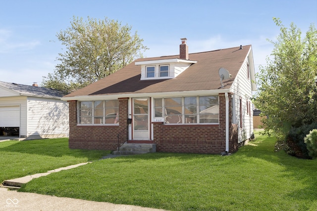 view of front of property with a garage and a front lawn