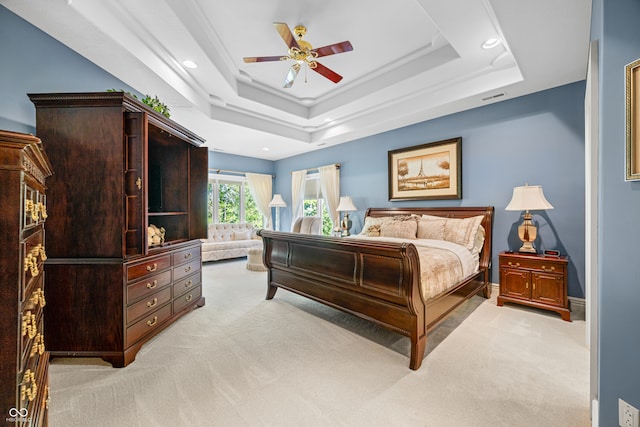 carpeted bedroom featuring ceiling fan and a tray ceiling