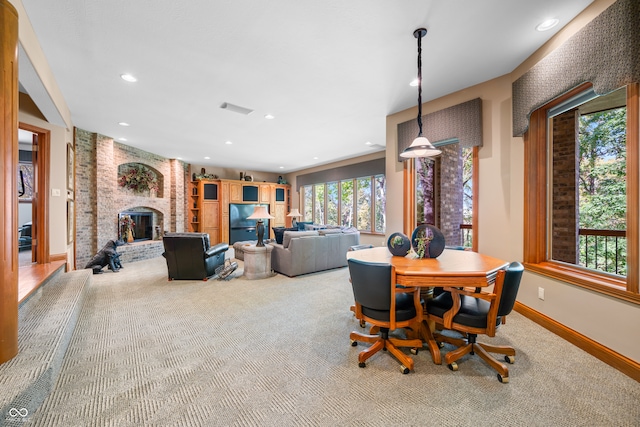 dining space with a fireplace and carpet floors