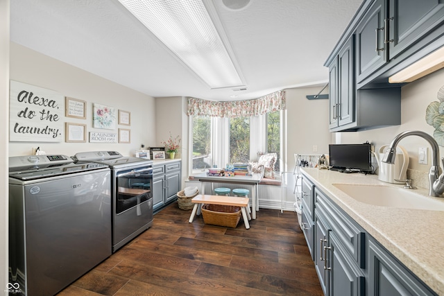 kitchen with dark hardwood / wood-style floors, sink, washing machine and dryer, and gray cabinetry