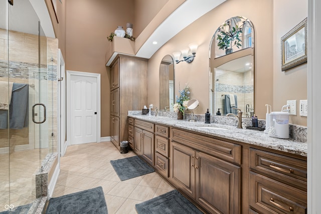 bathroom with vanity, a towering ceiling, walk in shower, and tile patterned flooring