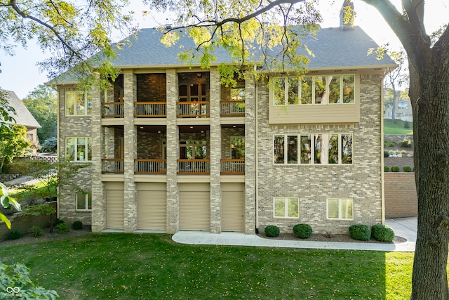 back of property with a yard and a balcony