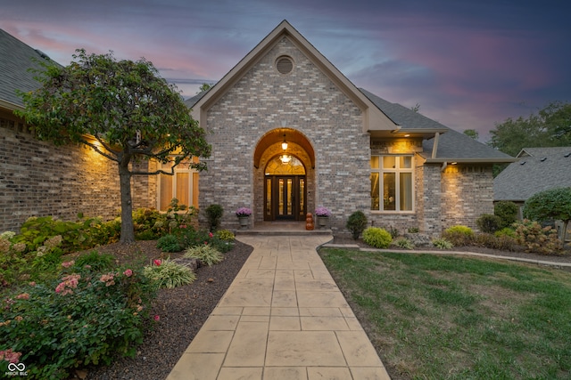 view of front facade featuring french doors and a yard