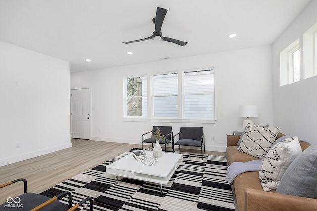 living room featuring ceiling fan, plenty of natural light, and light hardwood / wood-style flooring