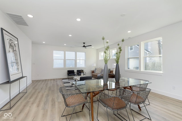 dining space with light hardwood / wood-style floors and ceiling fan