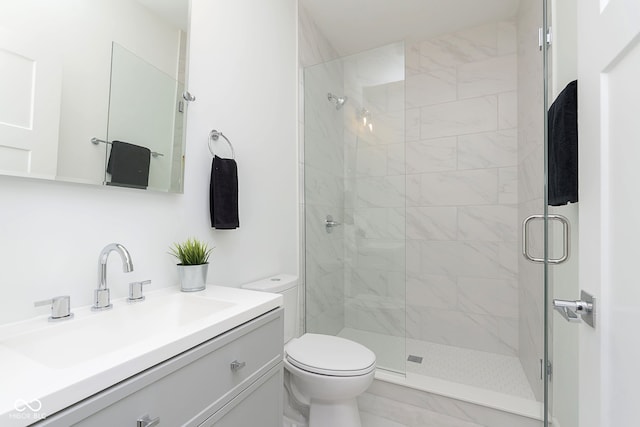 bathroom featuring vanity, toilet, and a shower with door