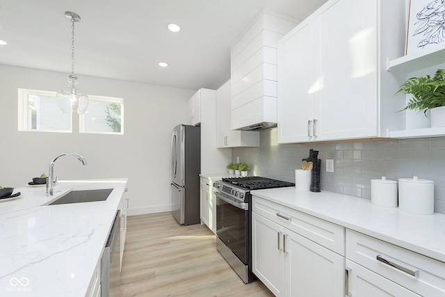 kitchen featuring stainless steel appliances, white cabinetry, and sink