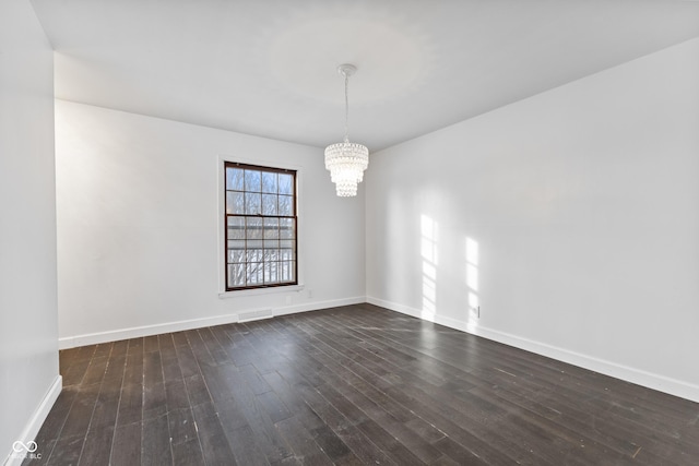 empty room featuring an inviting chandelier and dark wood-type flooring