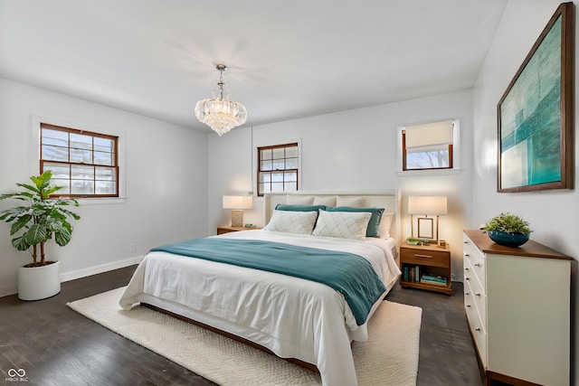 bedroom featuring multiple windows, a chandelier, and dark hardwood / wood-style flooring