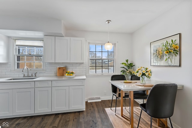 kitchen featuring sink, hanging light fixtures, plenty of natural light, and decorative backsplash