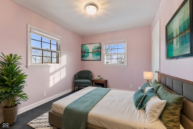 bedroom featuring multiple windows and dark hardwood / wood-style flooring