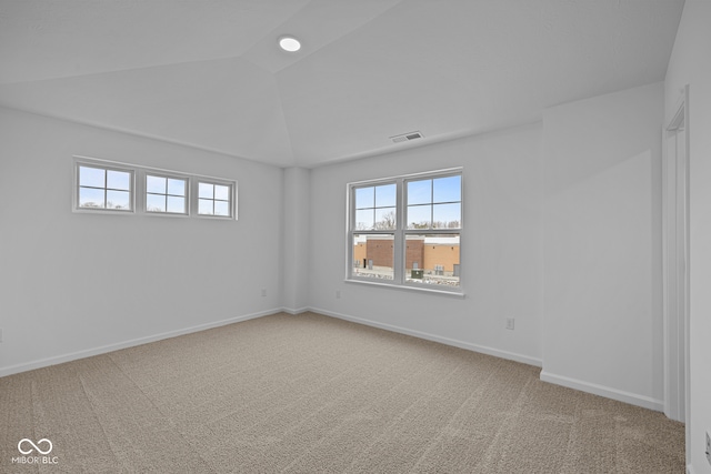 carpeted spare room with lofted ceiling