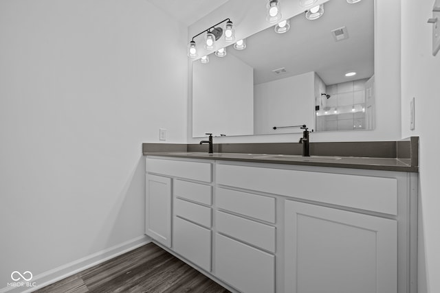 bathroom featuring vanity, wood-type flooring, and walk in shower