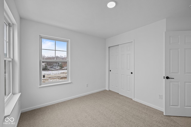 unfurnished bedroom featuring carpet floors and a closet