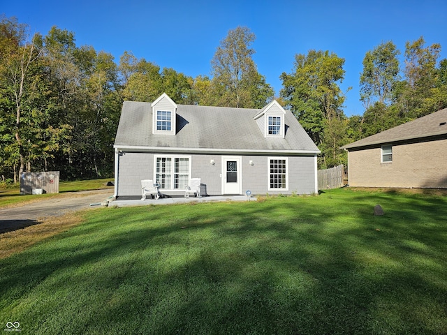 rear view of house featuring a lawn and a patio