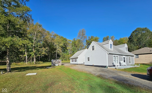 view of home's exterior with a yard and a patio area