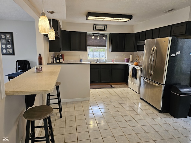 kitchen with hanging light fixtures, stainless steel appliances, a kitchen breakfast bar, kitchen peninsula, and light tile patterned floors