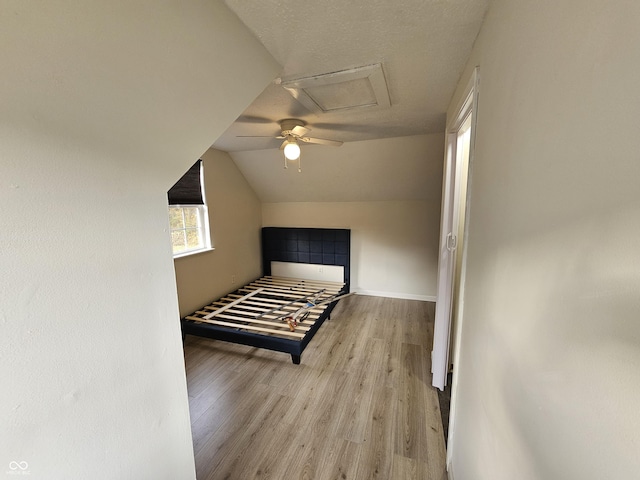 unfurnished bedroom featuring ceiling fan, lofted ceiling, and light hardwood / wood-style flooring