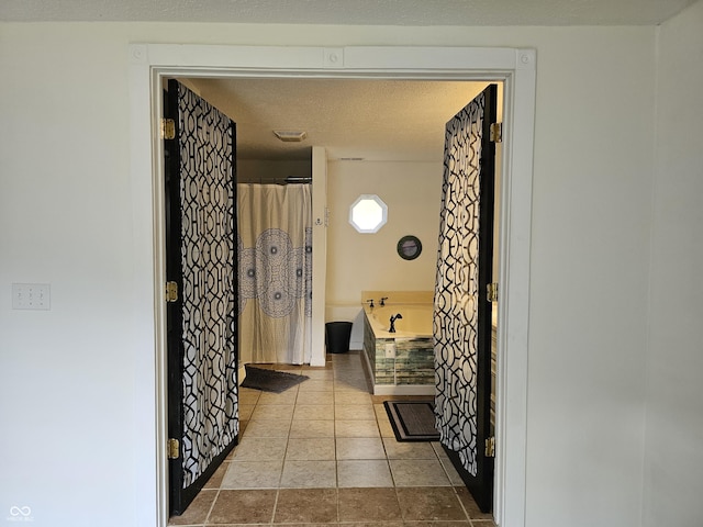 bathroom with tile patterned flooring and a tub