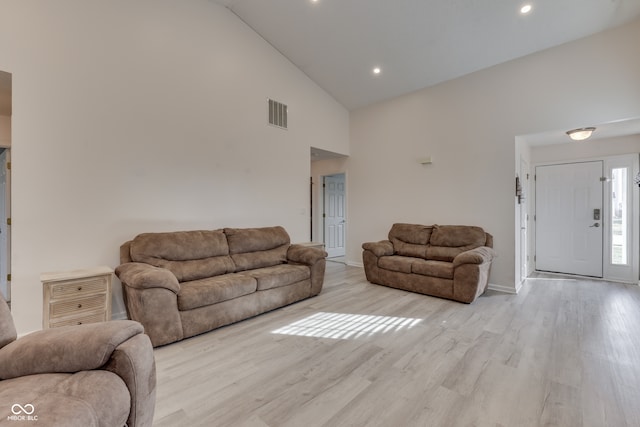 living room with high vaulted ceiling and light hardwood / wood-style floors