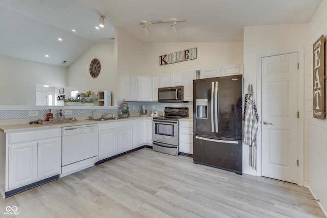 kitchen with stainless steel appliances, decorative backsplash, white cabinets, and light wood-type flooring