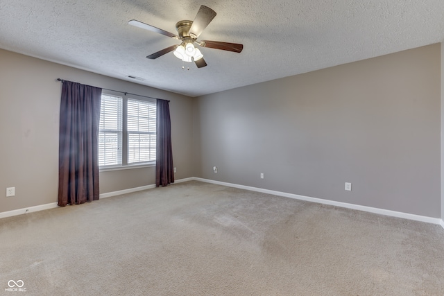 carpeted spare room featuring ceiling fan and a textured ceiling