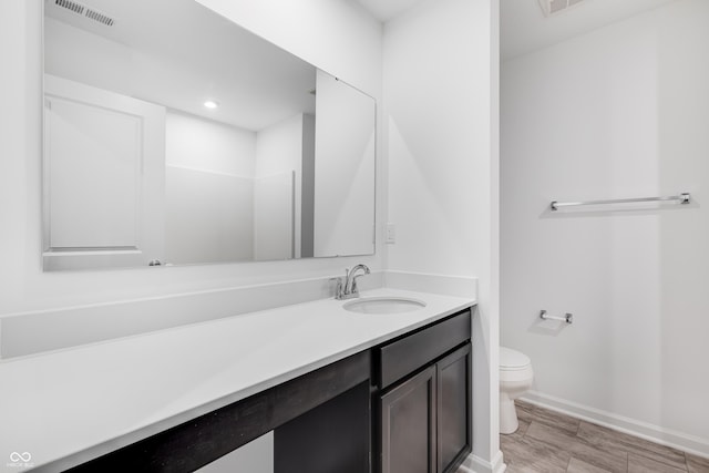 bathroom featuring hardwood / wood-style floors, vanity, and toilet