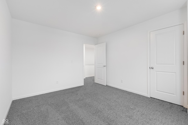 spare room with dark colored carpet