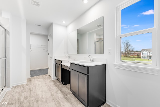 bathroom with vanity and a shower with door