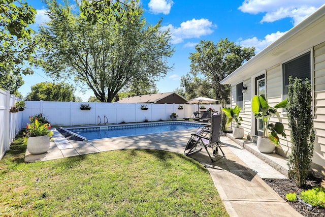 view of swimming pool featuring a patio and a yard