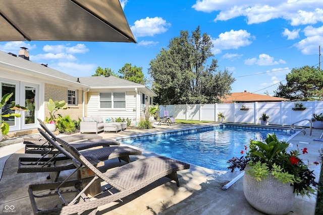 view of swimming pool featuring outdoor lounge area, french doors, and a patio