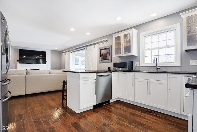 kitchen with stainless steel appliances, sink, dark hardwood / wood-style flooring, and white cabinetry