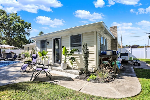 view of front of house with a swimming pool and a patio