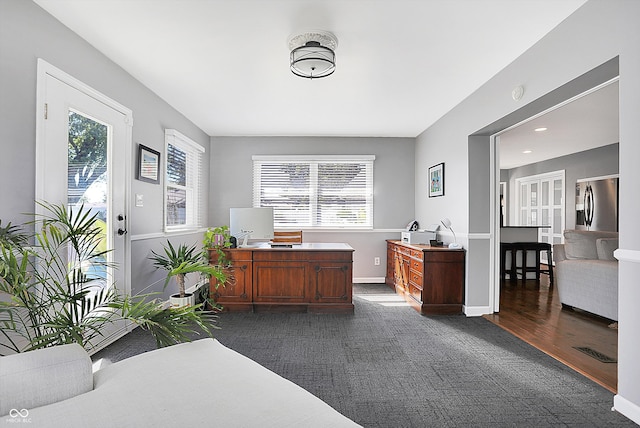 office with plenty of natural light and dark wood-type flooring